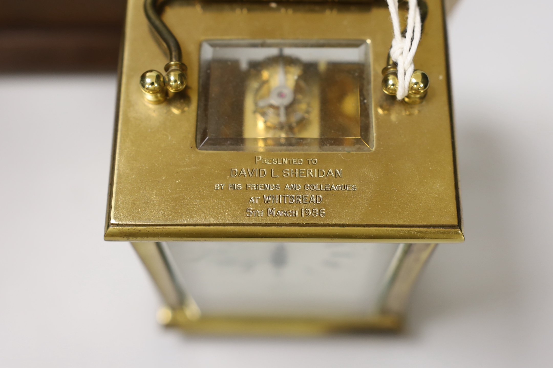 A brass presentation carriage clock together with an inlaid mahogany mantel clock